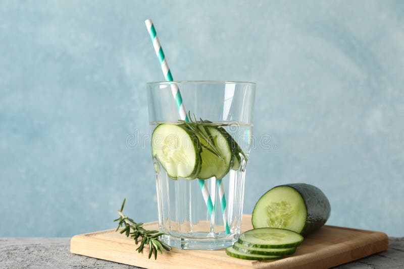 Composition with glass of cucumber water on table, close up. Composition with glass of cucumber water on grey table, close up stock photography