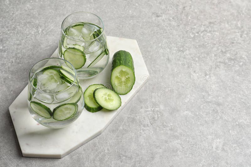 Composition with glasses of fresh cucumber water and space for text. On grey background royalty free stock photo