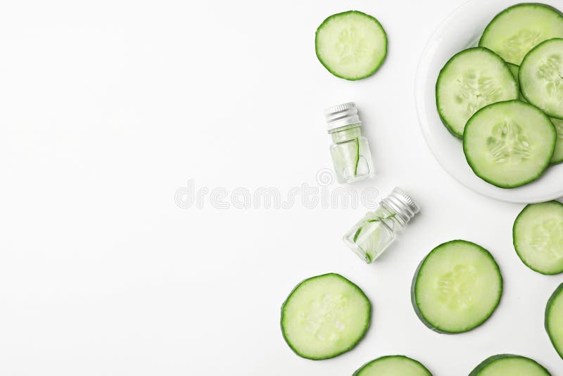 Flat lay composition with fresh cucumber skin care. Tonic and bottles on white background stock photos
