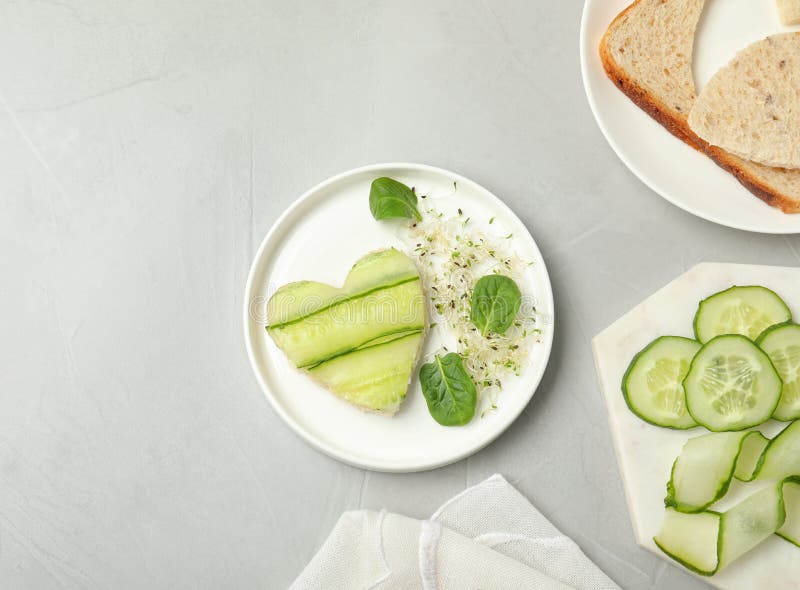 Flat lay composition with traditional English cucumber sandwich and ingredients on grey. Space for text. Flat lay composition with traditional English cucumber royalty free stock image