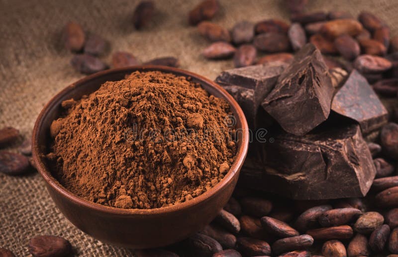 Raw cocoa beans, clay bowl with cocoa powder, chocolate on sack. Cocoa beans, clay bowl with cocoa powder, black chocolate on brown sacking royalty free stock photos