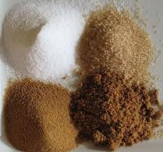 White Sugar, Evaporated Cane Juice, Brown Sugar & Demerrera Four piles of different types of sugar on a table: White Sugar, Evaporated Cane Juice, Brown Sugar & Demerrera.